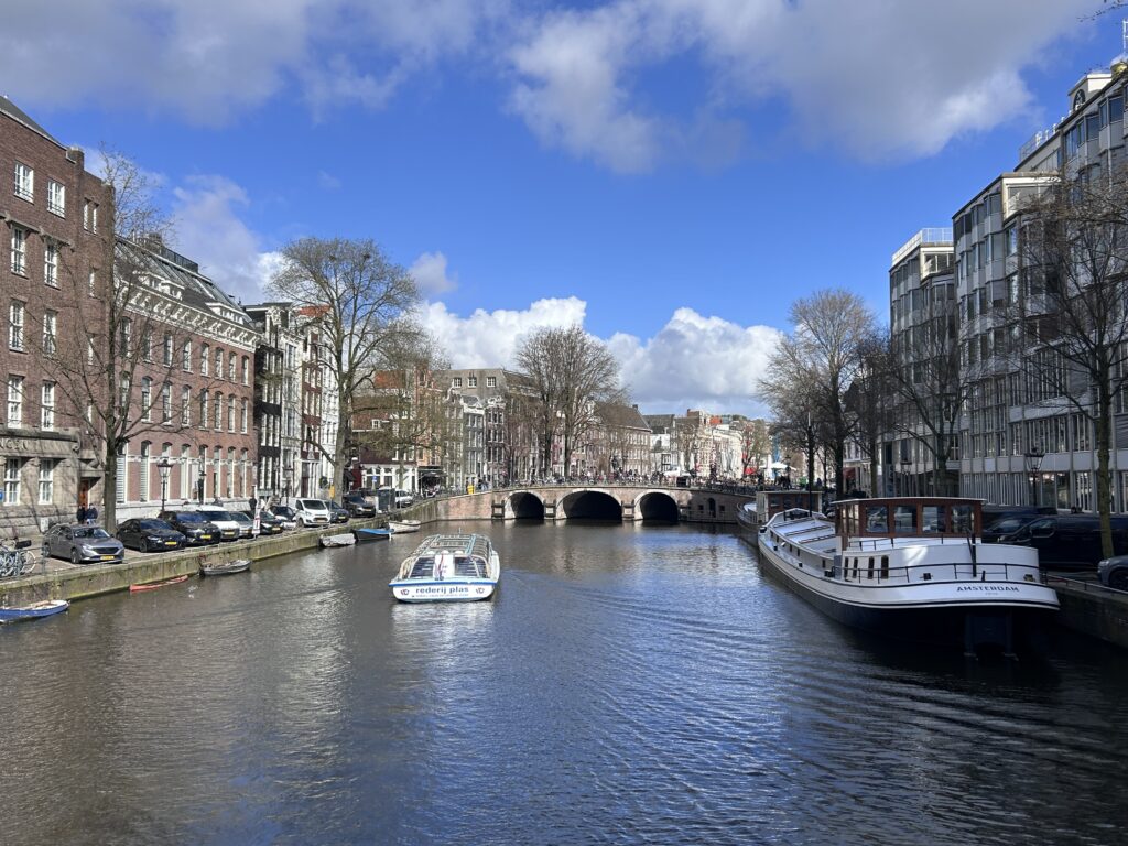 Picture of one of Amsterdam's canals with buildings on the background and boats.